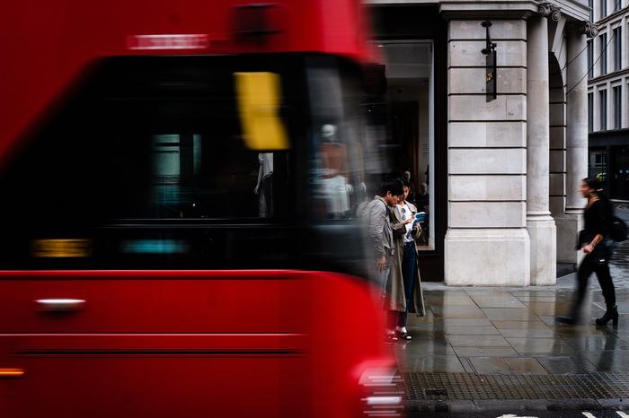 A red London bus on a city street